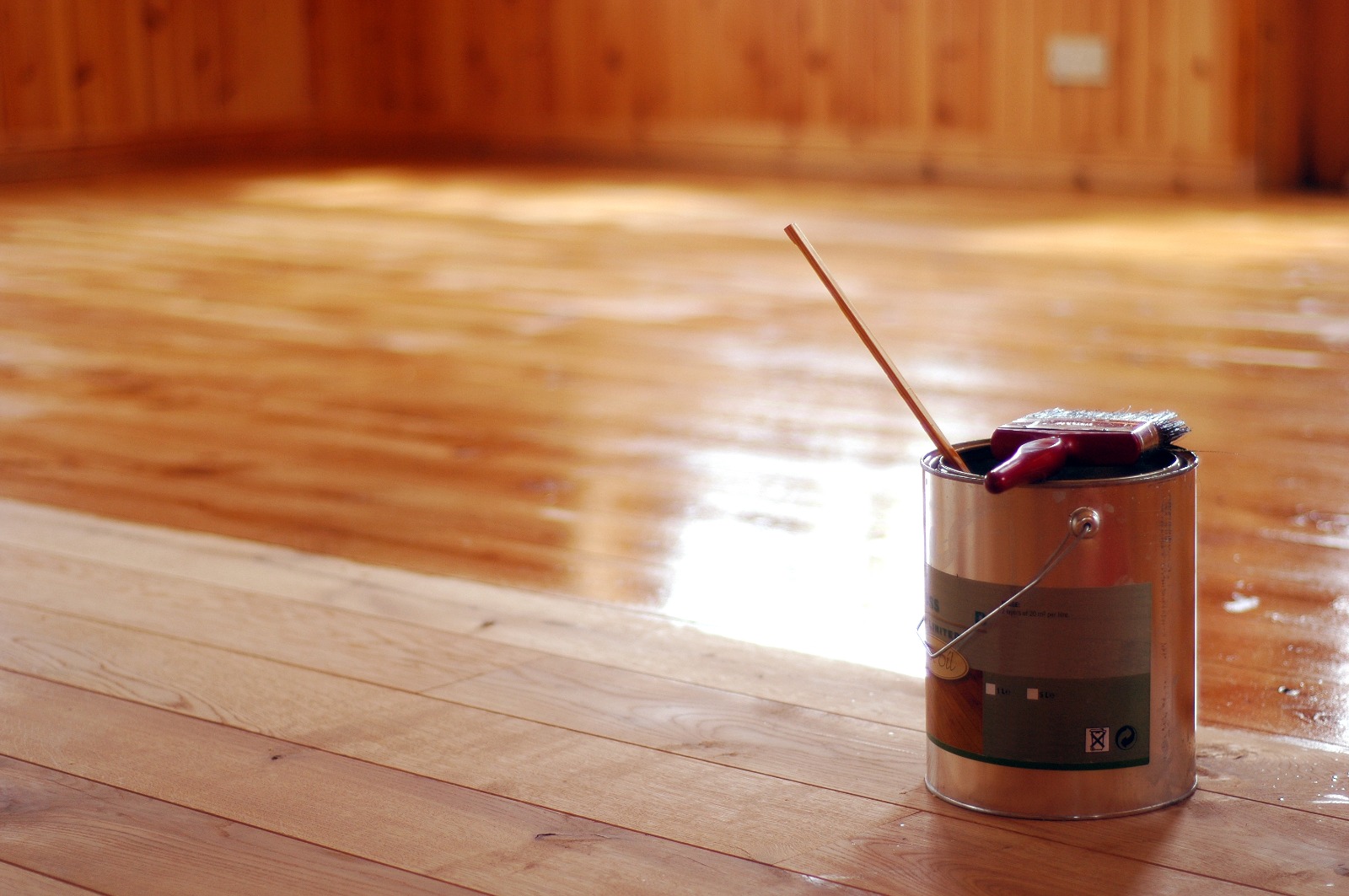 Grief Over Scratches in Egham – tin of clear finish and brushes on a European oak solid hardwood floor, mid-application to restore sheen and hide light scratches.