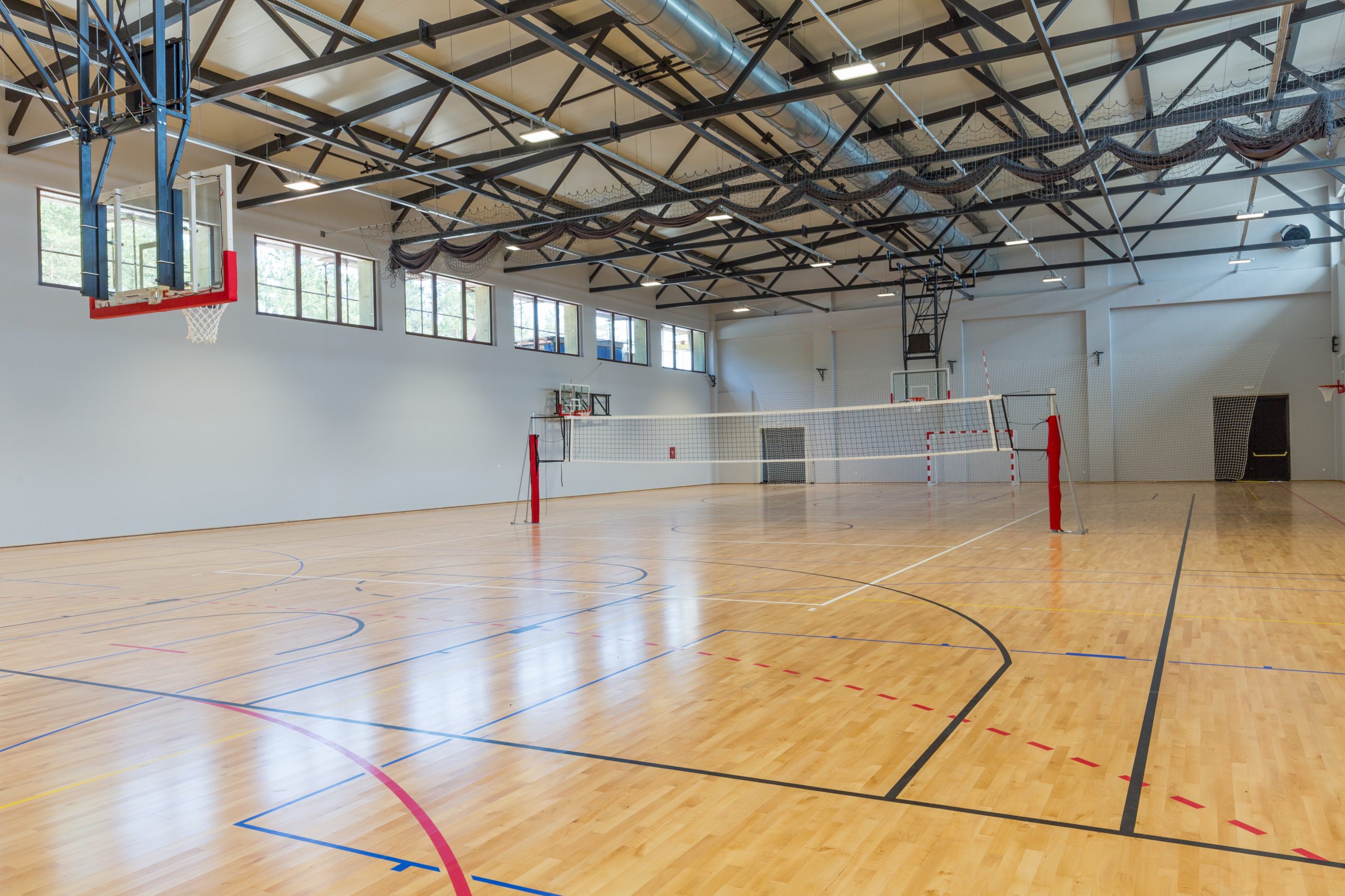 Commercial Floor Sanding in Egham on a maple hardwood sports hall floor, fully restored with fresh game court line markings.
