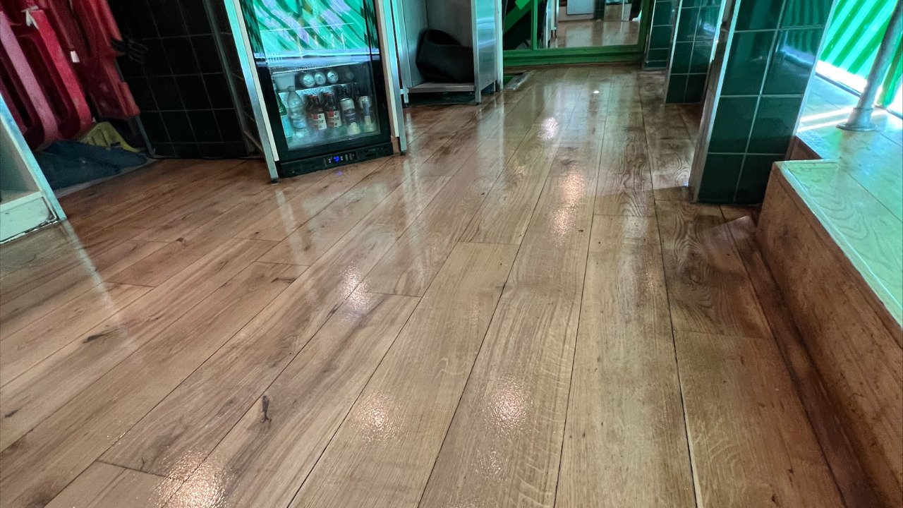 Commercial Floor Sanding in Egham on an oak hardwood bar floor, restored to a smooth, glossy finish in a busy commercial setting.